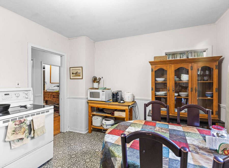This charming kitchen features a white stove with a patterned towel hanging from the oven door.