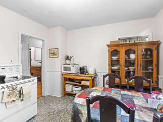 This charming kitchen features a white stove with a patterned towel hanging from the oven door.