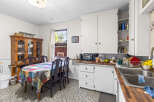 This charming kitchen features a spacious dining area with a colorful, patterned tablecloth and a traditional wooden hutch perfect for displaying dishware.