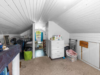 Discover versatile living in this charming attic space, perfect for a home office, playroom, or extra storage.