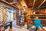 Explore the potential of this unfinished basement, featuring a functional water heater and ample storage shelves perfect for organizing your belongings.