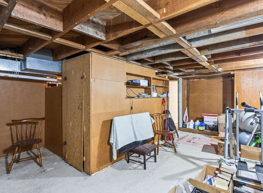 Explore the potential of this unfinished basement, featuring exposed wooden beams and ample space for customization.
