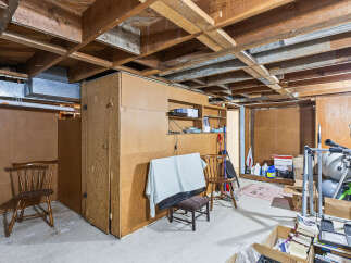 Explore the potential of this unfinished basement, featuring exposed wooden beams and ample space for customization.