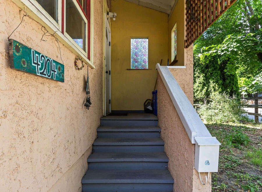 Welcome guests with this charming entryway featuring a decorative house number sign and a welcoming porch.