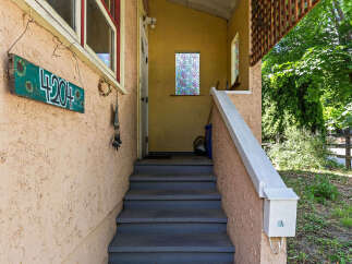 Welcome guests with this charming entryway featuring a decorative house number sign and a welcoming porch.