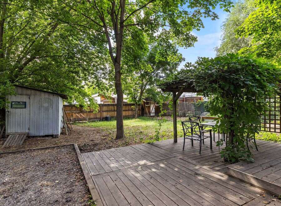 Enjoy outdoor living in this charming backyard featuring a spacious wooden deck perfect for entertaining.