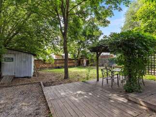 Enjoy outdoor living in this charming backyard featuring a spacious wooden deck perfect for entertaining.