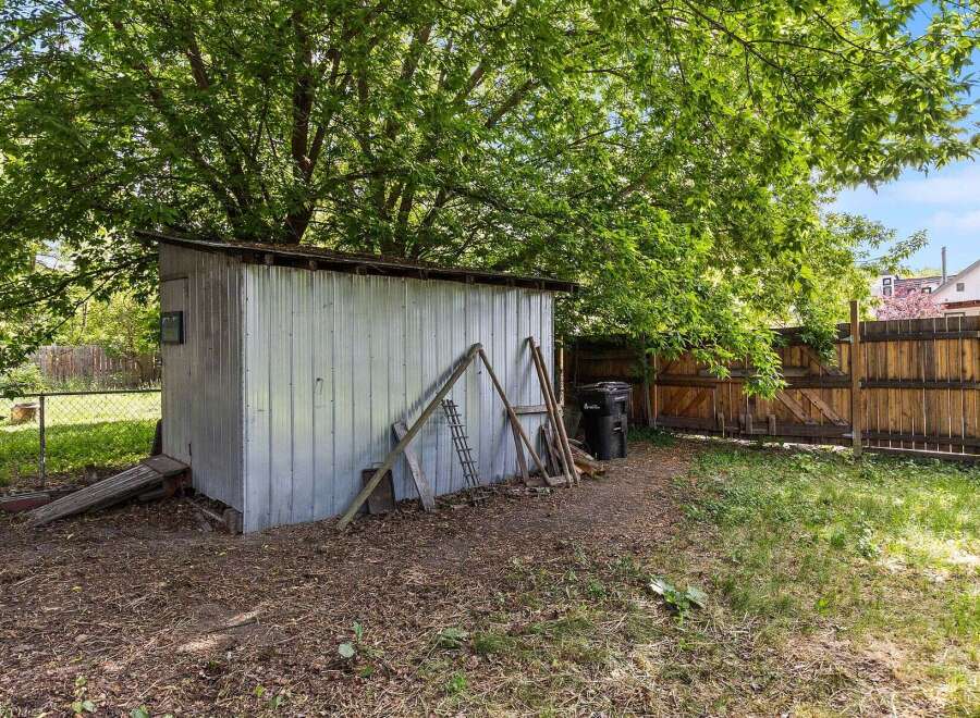 Discover the potential of this backyard space, featuring a versatile metal shed perfect for storage or a workshop.