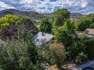Nestled amidst lush greenery and mature trees, this property offers a serene escape with picturesque views of rolling hills.