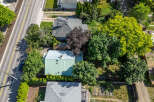 Discover this charming property featuring a well-maintained home with a distinctive green metal roof, nestled amidst lush greenery and mature trees.