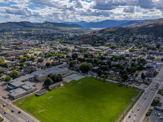 Discover this prime real estate opportunity featuring a spacious school building adjacent to a large, well-maintained sports field with soccer goals and tennis courts.