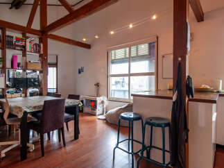 Discover this charming loft-style living space featuring exposed wooden beams and a bright, open-concept layout.