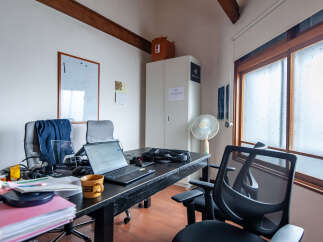 This office space features a large wooden desk equipped with a laptop and a coffee mug, perfect for productivity.