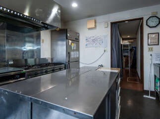 This commercial kitchen features a spacious stainless steel prep table, perfect for busy food service operations.