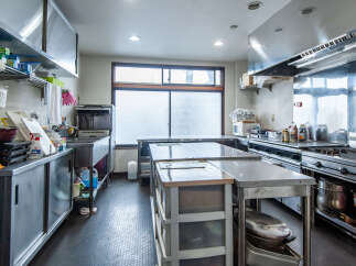 This commercial kitchen boasts a spacious stainless steel workspace, perfect for a bustling restaurant or catering business.