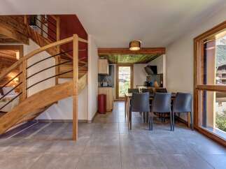 Experience modern alpine living in this beautifully appointed apartment, featuring a stunning wooden spiral staircase leading to the upper levels.