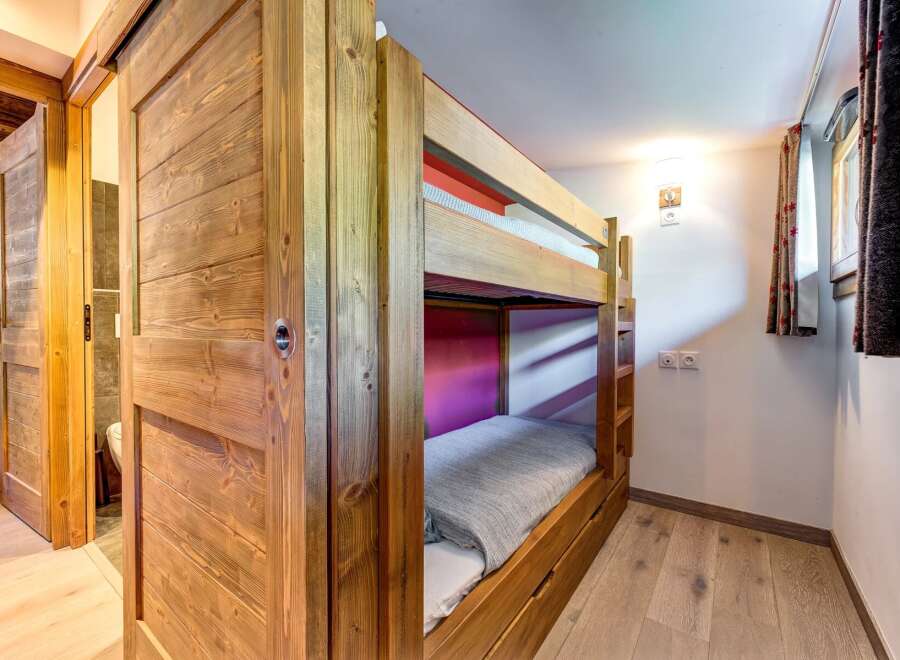 This charming room features a sturdy wooden bunk bed, perfect for accommodating guests or family.