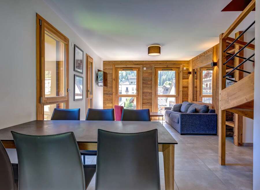 Experience mountain living in this beautifully appointed apartment, featuring a spacious dining area with sleek leather chairs and a modern table.