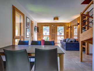 Experience mountain living in this beautifully appointed apartment, featuring a spacious dining area with sleek leather chairs and a modern table.