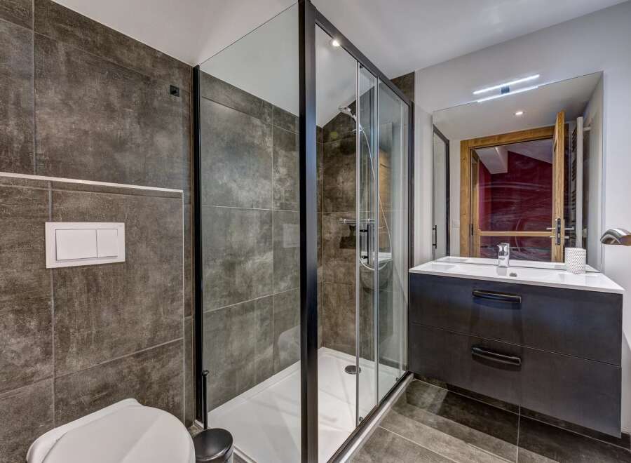 Experience modern luxury in this stunning bathroom featuring a spacious glass-enclosed shower with sleek black trim.