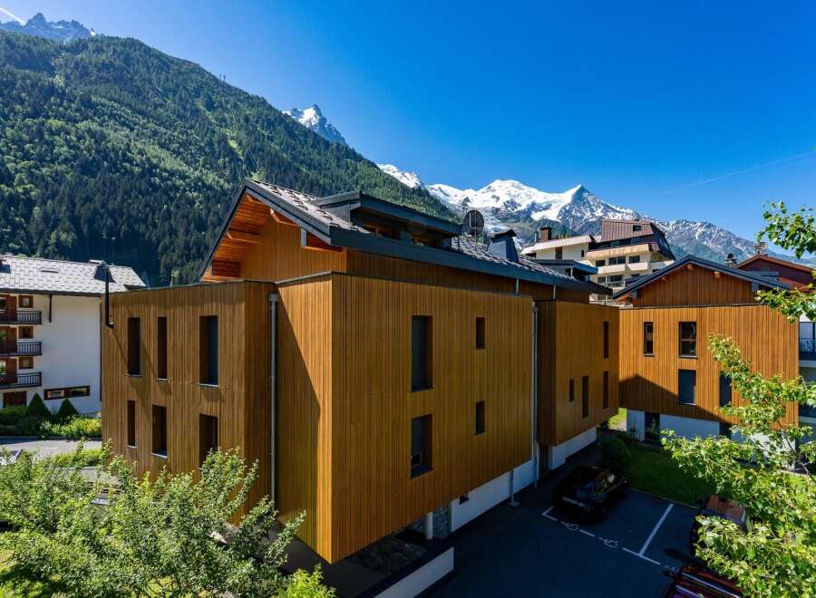Experience modern alpine living in this stunning property featuring contemporary wooden architecture that seamlessly blends with the majestic mountain backdrop.