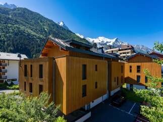 Experience modern alpine living in this stunning property featuring contemporary wooden architecture that seamlessly blends with the majestic mountain backdrop.