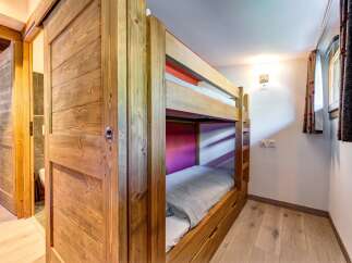This charming room features a sturdy wooden bunk bed, perfect for accommodating guests or family.