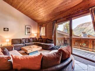 Experience cozy mountain living in this charming living room, featuring a large sectional sofa perfect for gathering.