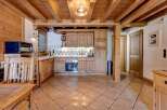 Experience rustic charm in this beautifully appointed kitchen, featuring warm wooden cabinetry and exposed beams that create a cozy, inviting atmosphere.