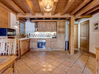 Experience rustic charm in this beautifully appointed kitchen, featuring warm wooden cabinetry and exposed beams that create a cozy, inviting atmosphere.