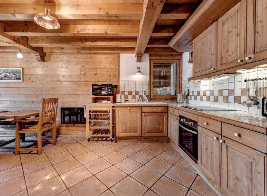 Experience rustic charm in this cozy wooden kitchen, featuring warm pine cabinetry and exposed beams.