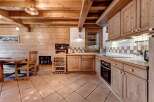 Experience rustic charm in this cozy wooden kitchen, featuring warm pine cabinetry and exposed beams.
