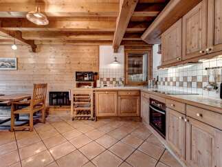 Experience rustic charm in this cozy wooden kitchen, featuring warm pine cabinetry and exposed beams.