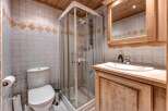 This charming bathroom features a modern glass-enclosed shower, a pristine white toilet, and a stylish vanity with a sink.