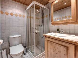 This charming bathroom features a modern glass-enclosed shower, a pristine white toilet, and a stylish vanity with a sink.