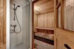 Experience ultimate relaxation in this luxurious spa-like bathroom featuring a private sauna with wooden benches and a separate shower area.