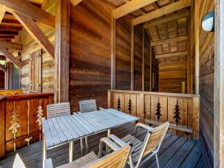 Enjoy your morning coffee or evening drinks on this charming wooden balcony, complete with a rustic table and chairs.