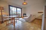 Enjoy stunning mountain views from this charming apartment, featuring a cozy living area with a sofa and coffee table, perfect for relaxing after a day of skiing.