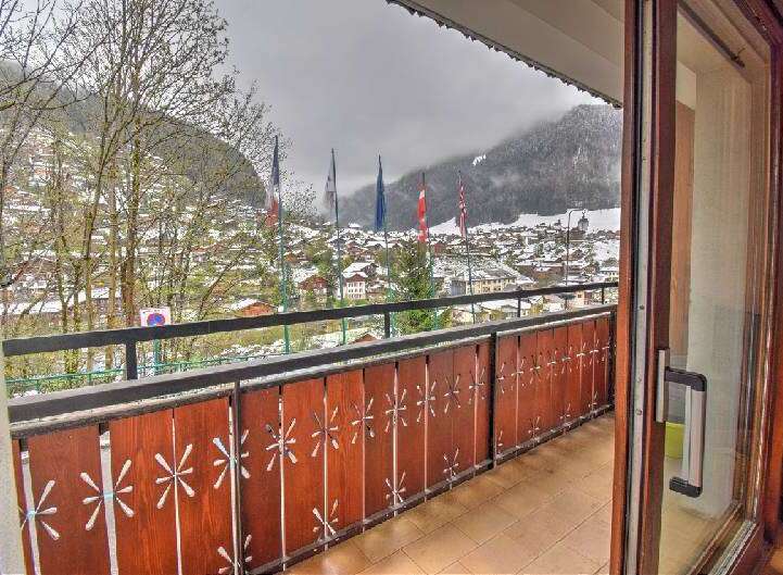 Enjoy breathtaking mountain views from this charming balcony overlooking a snow-dusted village.