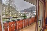 Enjoy breathtaking mountain views from this charming balcony overlooking a snow-dusted village.