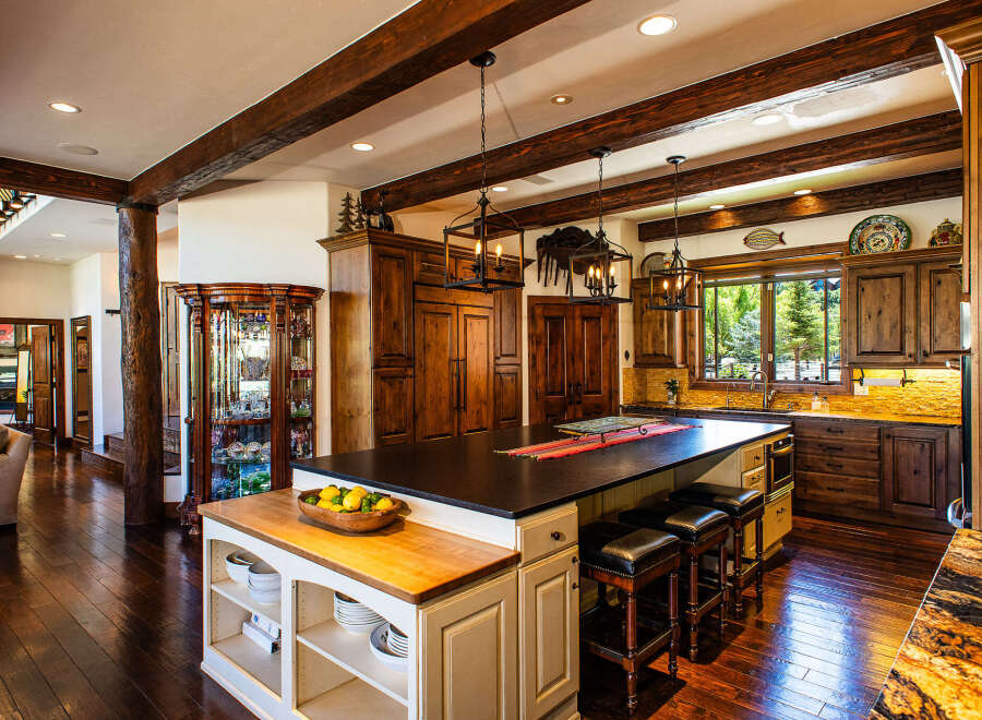 Experience rustic luxury in this stunning mountain kitchen, featuring rich wooden cabinetry, exposed beams, and a spacious island perfect for entertaining.
