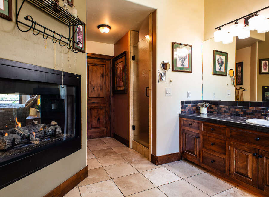 Experience luxury and comfort in this stunning master bathroom, featuring a cozy gas fireplace perfect for relaxing evenings.