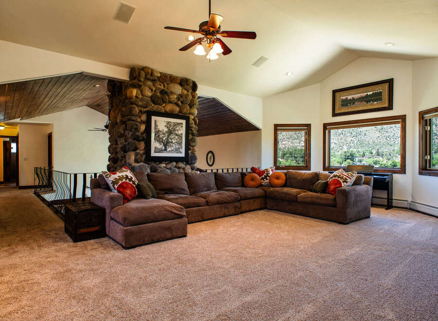 Experience breathtaking mountain views from this spacious living room, featuring a large sectional sofa perfect for gatherings.