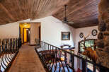 Experience rustic elegance in this stunning home featuring a grand wooden-beamed ceiling and a unique stone fireplace.