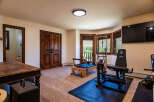 This home gym features a variety of exercise equipment, including a Pilates reformer and a weight machine, perfect for a full-body workout.