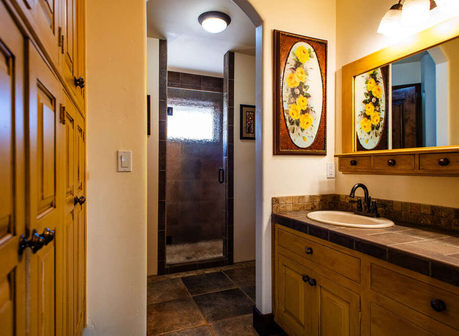 This charming bathroom features a spacious walk-in shower with elegant tile work and a frosted glass door.
