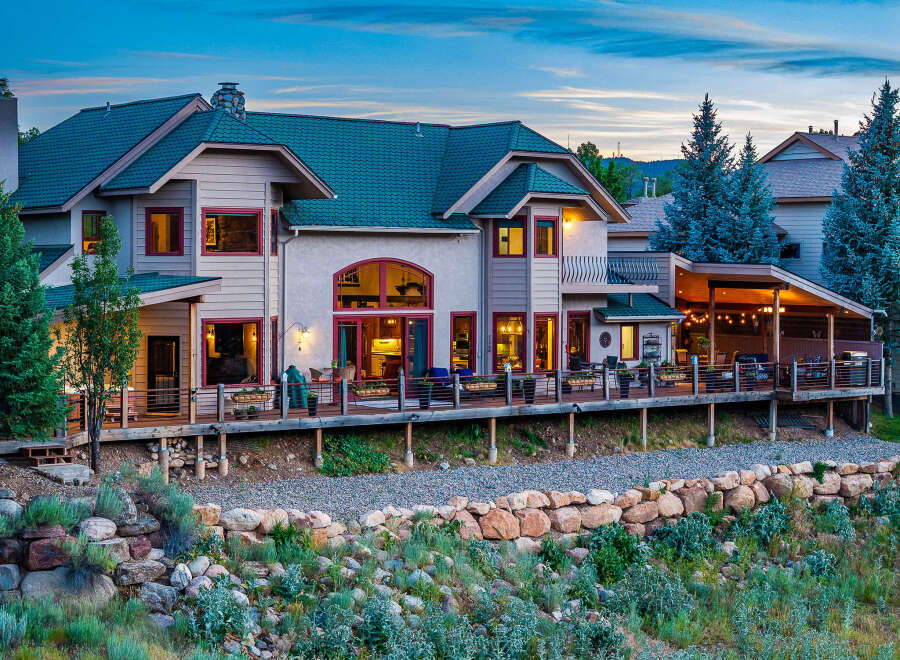 Experience luxury mountain living in this stunning custom-built home, featuring expansive decks and a covered patio perfect for entertaining.