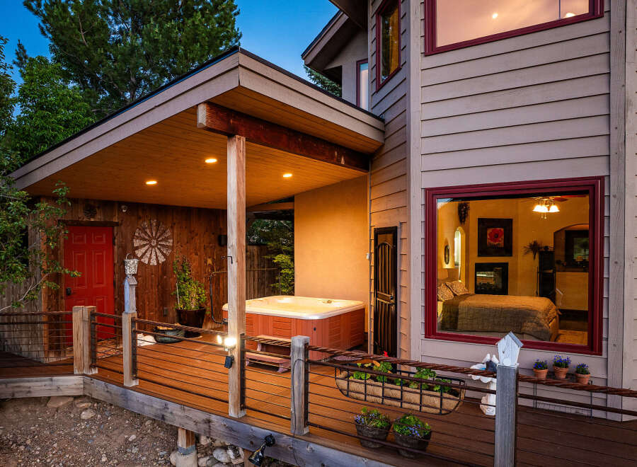 Experience ultimate relaxation in this stunning home featuring a luxurious hot tub on a spacious wooden deck, perfect for unwinding under the stars.