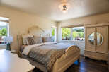 Experience serene living in this charming bedroom, featuring a beautifully appointed bed with a decorative headboard and a coordinating duvet.
