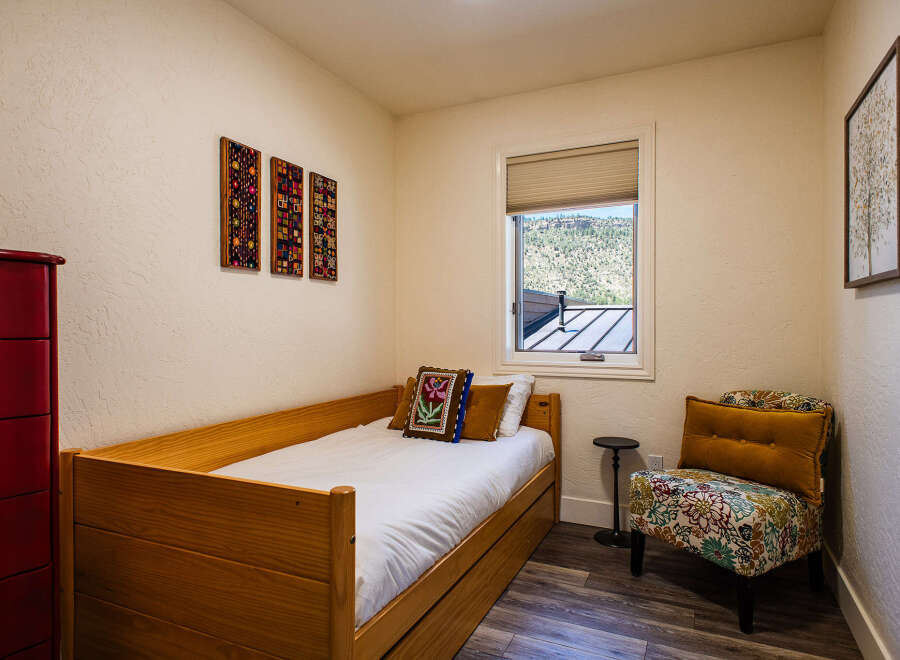 This charming bedroom features a cozy wooden daybed, perfect for relaxation or as a guest sleeping area.